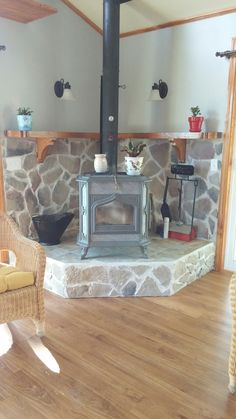 a living room with a stone fireplace and wicker chairs