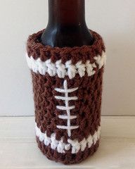 a crocheted beer bottle cozy with a football on the front and white stitching