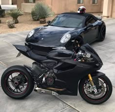 a black motorcycle parked in front of a car