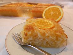 a slice of orange cake on a plate with a fork