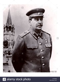 a black and white photo of a man in uniform with a clock tower in the background