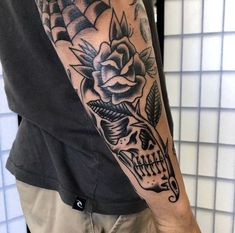 a man with a skull and flower tattoo on his arm