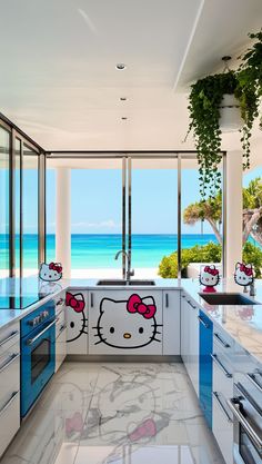 a kitchen with hello kitty decals on the wall and counters in front of an ocean view