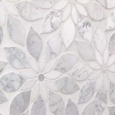 a marble wall with white and grey flowers on it's side, as well as the top part of an intricate design