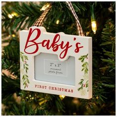 a baby's first christmas ornament hanging from a christmas tree