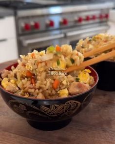 two bowls filled with rice and vegetables on top of a wooden table next to an oven