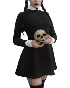 a woman in a black dress holding a skull