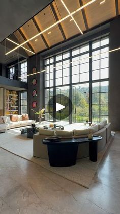 a large living room with high ceilings and floor to ceiling windows