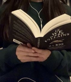 a girl wearing headphones and reading a book