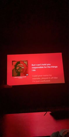 a man standing in front of a red screen with a message on it that reads, but i can't hold you