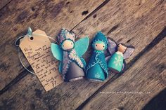 two little blue angel figurines sitting on top of a wooden table