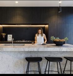 a woman sitting at a counter in a kitchen