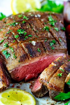 a piece of steak on a plate with lemons and parsley