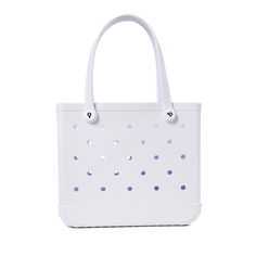 a white handbag with blue dots on the front and bottom, sitting against a white background