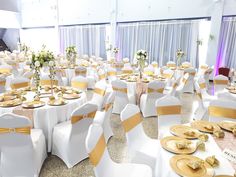 the banquet hall is set up with white and gold linens