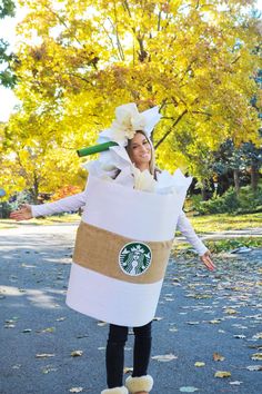 a woman in a starbucks bag costume is walking down the street