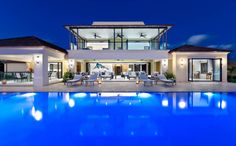 a large house with a swimming pool in front of it at night or day time