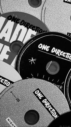 there are many different cd's on the table and one is black and white