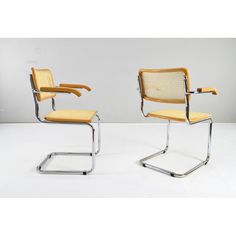 a pair of chairs with yellow upholstered fabric and chrome frame, on white background