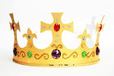 a gold crown with jewels and stones on the sides is shown in front of a white background