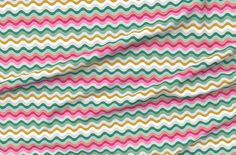 an image of a colorful fabric with wavy lines on it's surface and the colors of pink, green, yellow, and white