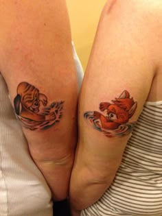 two women with matching tattoos on their legs, both holding each other's arms