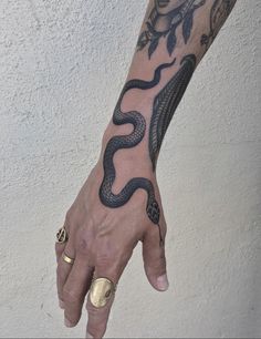 a hand with a snake tattoo on it