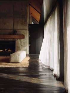 a living room with a fireplace and white curtains