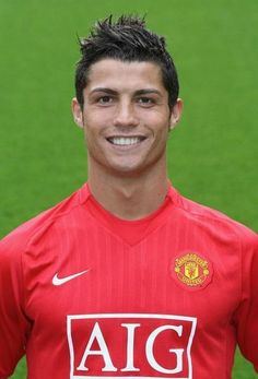 a young man in a red shirt is posing for a photo on the soccer field