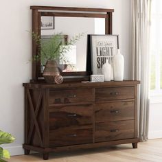 a wooden dresser sitting next to a window with a mirror on it's side