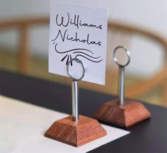 two wooden stands with signs on them that say williams nicholas and one has a ring in it