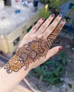 a woman's hand with henna tattoos on it