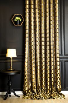 a black and gold room with a lamp on the side table in front of it