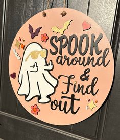 a wooden sign that says spook around and find out on the front door,