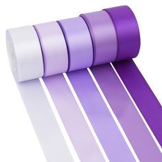 four rolls of purple and white satin ribbons