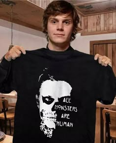 a man holding up a t - shirt with the words all monsters are human on it