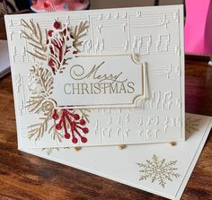 a white christmas card sitting on top of a wooden table