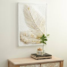 a plant is sitting on top of a dresser next to a wall hanging above it