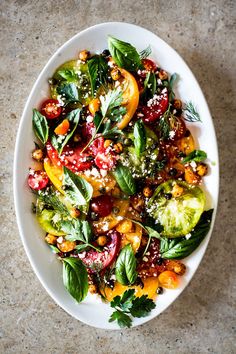 a white bowl filled with lots of different types of food on top of a table