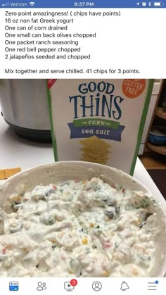 a bowl of food sitting on top of a table next to a box of chips