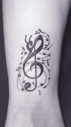 a tattoo on the foot of a person with musical notes and trebles around it