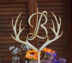 a cake topper made to look like antlers with the letter b on it