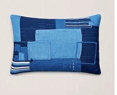 a blue patchwork pillow on a white wall