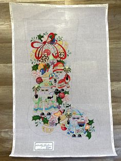 an embroidered christmas stocking hanging on a wooden wall