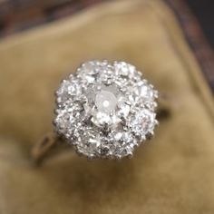 an antique diamond ring sitting on top of a velvet box