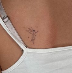 a small tattoo on the back of a woman's upper body, with a tiny tinkerbell