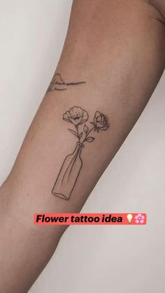 a woman's arm with a flower in a vase tattoo on the left forearm