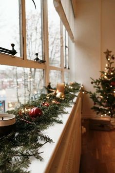 a window sill with christmas decorations and candles on the windowsill in front of it