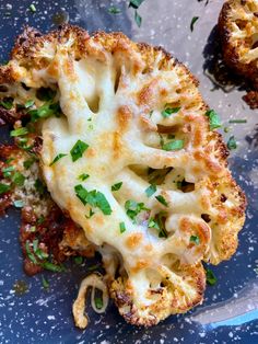 cooked cauliflower on a blue plate with parsley sprinkled on top