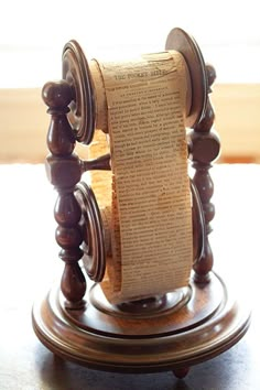 an old fashioned wooden spinning wheel with paper on it